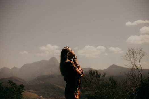 woman praying in the mountains